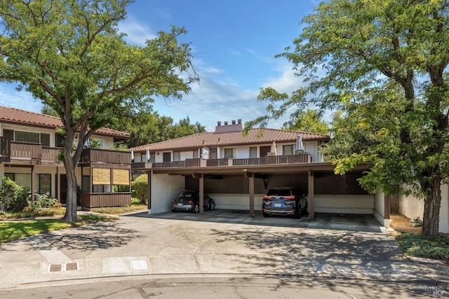 view of front of property with a balcony and a carport