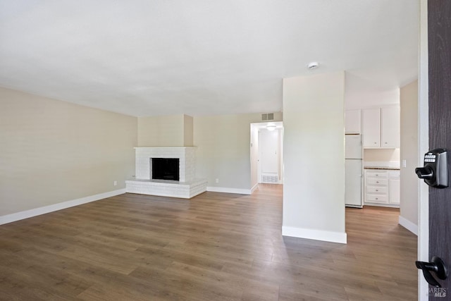 unfurnished living room featuring hardwood / wood-style flooring and a fireplace