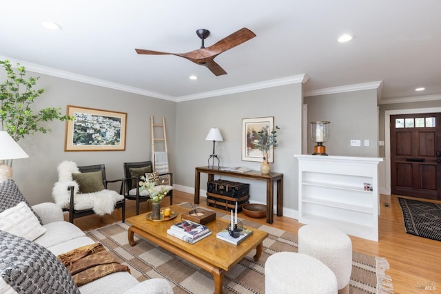 living room with ornamental molding, light hardwood / wood-style flooring, and ceiling fan