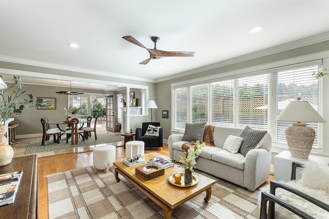 living room featuring ornamental molding, hardwood / wood-style floors, and ceiling fan