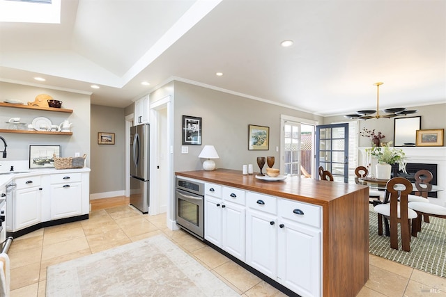 kitchen with white cabinets, vaulted ceiling, stainless steel appliances, and sink