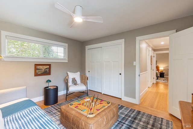 bedroom with ceiling fan, a closet, and light hardwood / wood-style floors