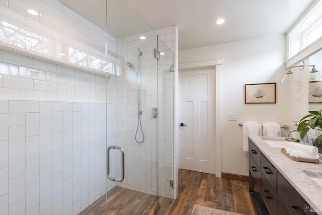 bathroom featuring vanity, a shower with door, and wood-type flooring