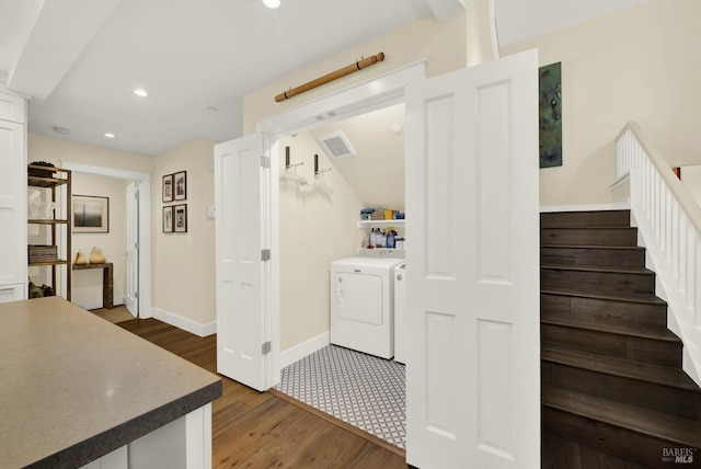 clothes washing area with laundry area, dark wood-type flooring, visible vents, baseboards, and washer and dryer