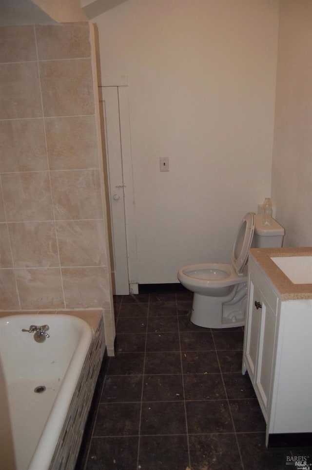 bathroom featuring a washtub, tile patterned floors, vanity, and toilet