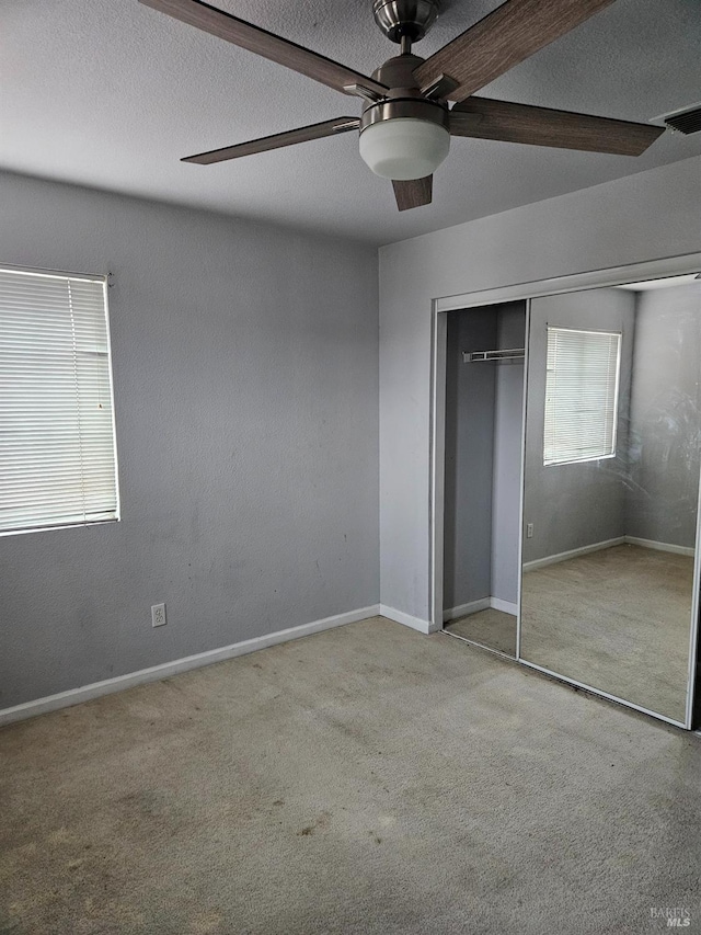 unfurnished bedroom featuring a closet, visible vents, light carpet, and a textured ceiling