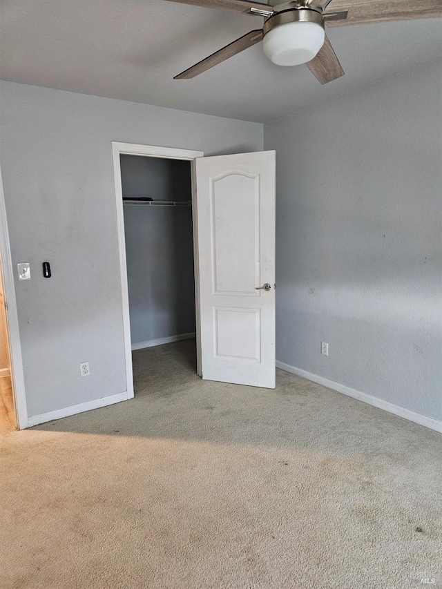 unfurnished bedroom featuring baseboards, a closet, a ceiling fan, and light colored carpet