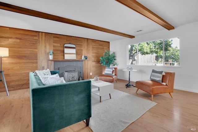 living room featuring hardwood / wood-style floors, wooden walls, and beamed ceiling