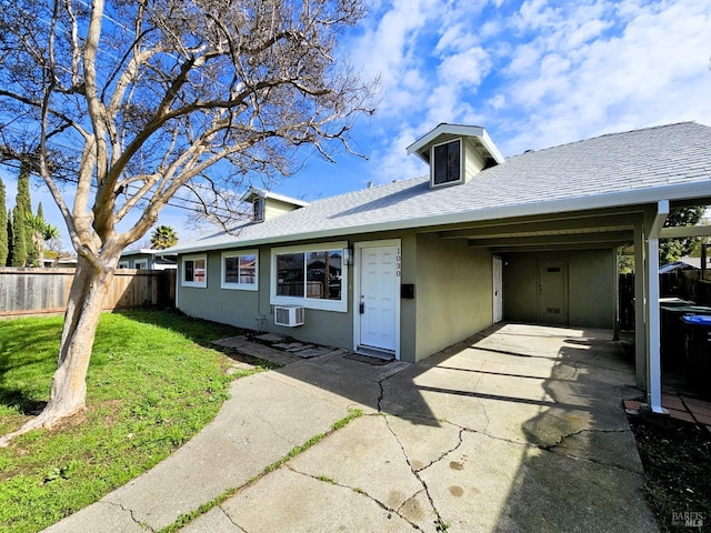 ranch-style house featuring a carport, a wall mounted AC, and a front lawn