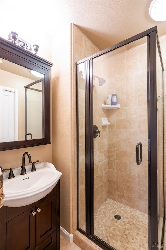 bathroom featuring vanity and a shower stall