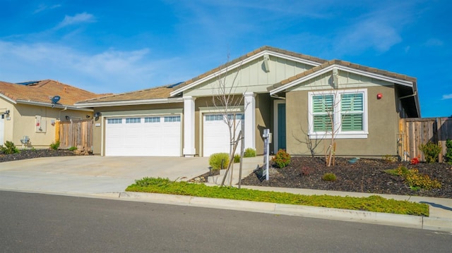 ranch-style home featuring a garage, driveway, fence, and stucco siding