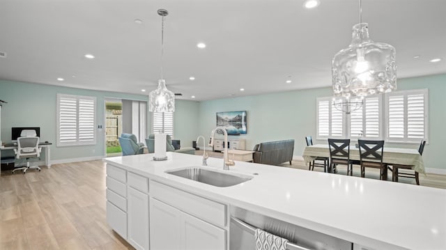 kitchen with light wood-style flooring, open floor plan, a sink, and recessed lighting