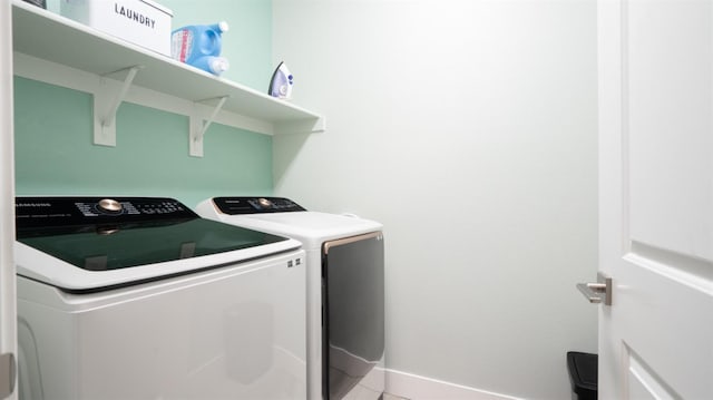 washroom with laundry area, baseboards, and separate washer and dryer