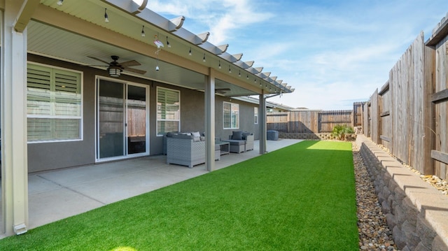 view of yard featuring ceiling fan, a patio area, a fenced backyard, and an outdoor living space