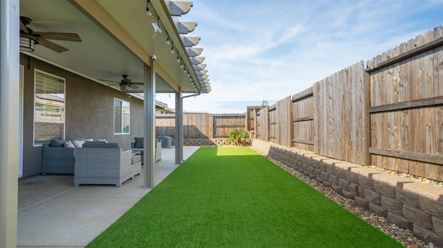 view of yard with a ceiling fan, central AC, a patio area, a fenced backyard, and an outdoor living space