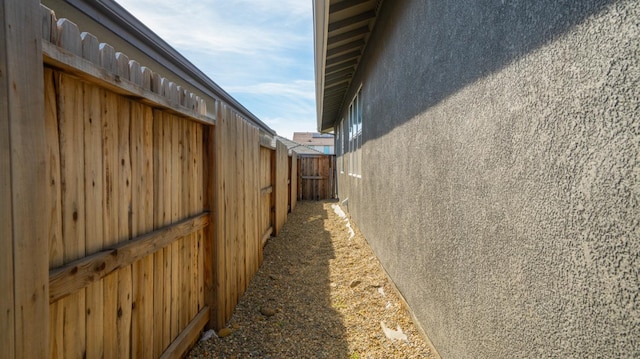 view of side of home featuring fence and stucco siding