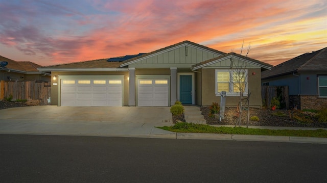 view of front of property with a garage, concrete driveway, board and batten siding, and fence