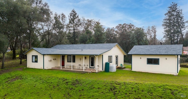 back of house with a lawn and a patio area