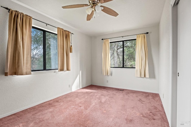 spare room with carpet floors, ceiling fan, and a healthy amount of sunlight