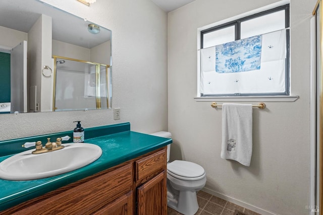 bathroom featuring vanity, tile patterned flooring, toilet, and a shower with shower door