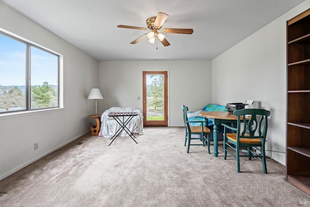 carpeted dining room with a healthy amount of sunlight and ceiling fan