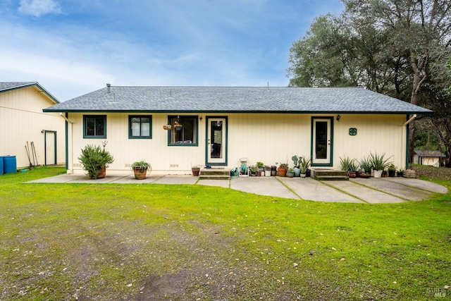 rear view of property with a lawn and a patio