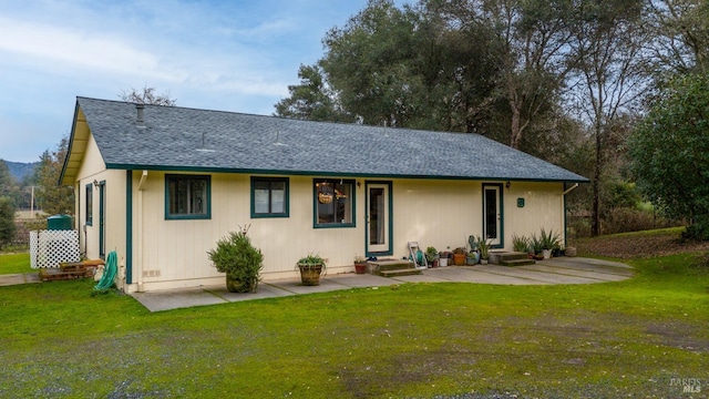 rear view of house featuring a lawn and a patio area