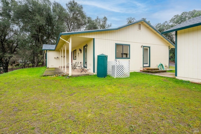 back of property with a lawn and a patio area