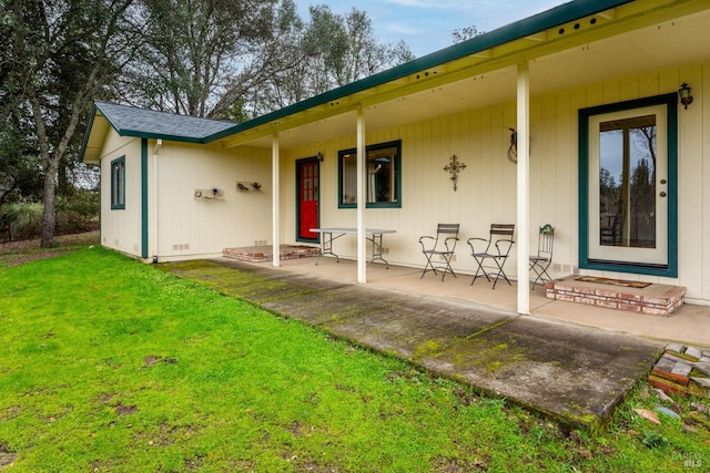 rear view of house with a porch and a lawn