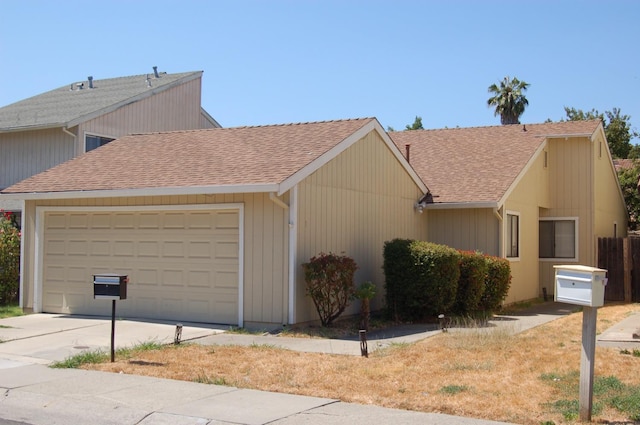 view of front of house featuring a garage, driveway, and roof with shingles