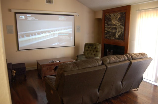 cinema room with vaulted ceiling and dark hardwood / wood-style flooring