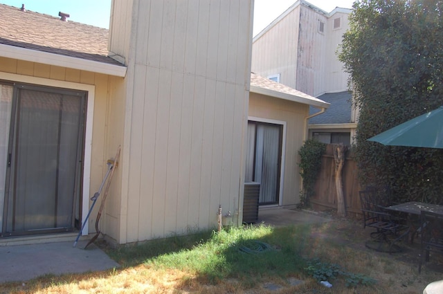 exterior space featuring a shingled roof and fence