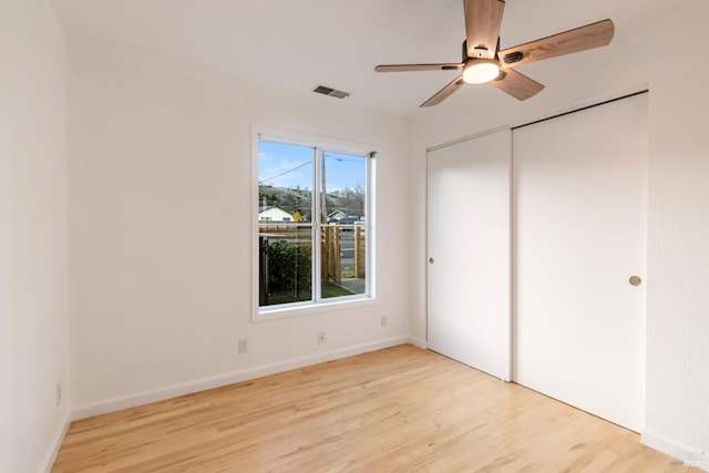 unfurnished bedroom with light wood-type flooring, a closet, and ceiling fan