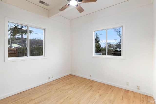 spare room featuring a healthy amount of sunlight, ceiling fan, and light hardwood / wood-style floors