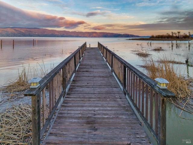 view of dock with a water and mountain view