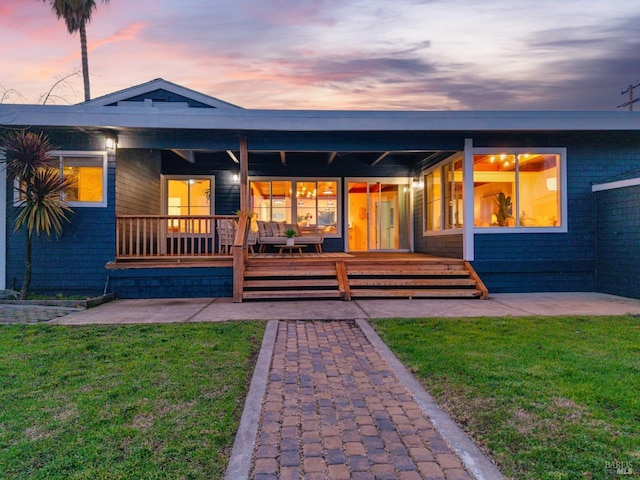 back house at dusk featuring a yard