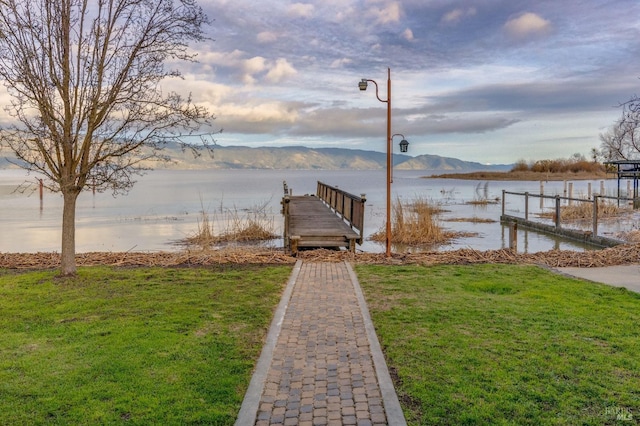 dock area featuring a yard and a water and mountain view