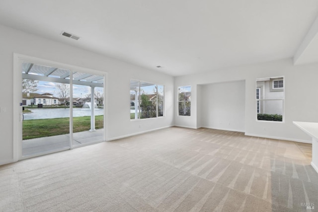 unfurnished living room with a water view and light colored carpet