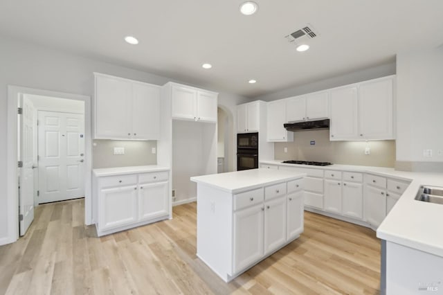 kitchen with white cabinetry, light wood-type flooring, gas cooktop, and black microwave