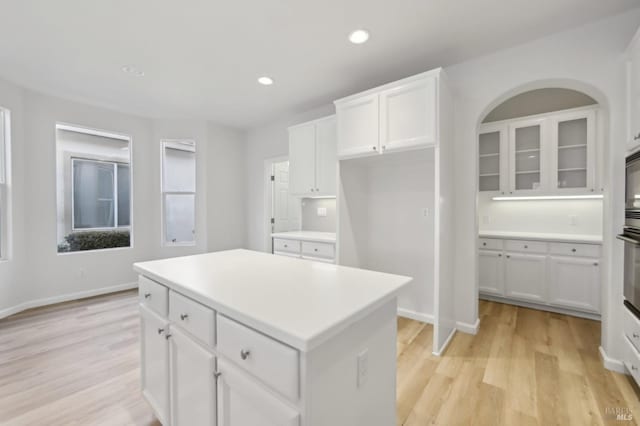 kitchen featuring light wood-type flooring, white cabinetry, and a center island