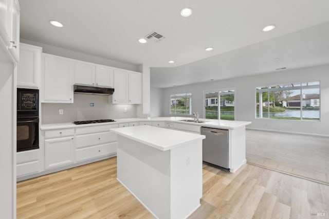 kitchen featuring sink, oven, a kitchen island, stainless steel dishwasher, and kitchen peninsula