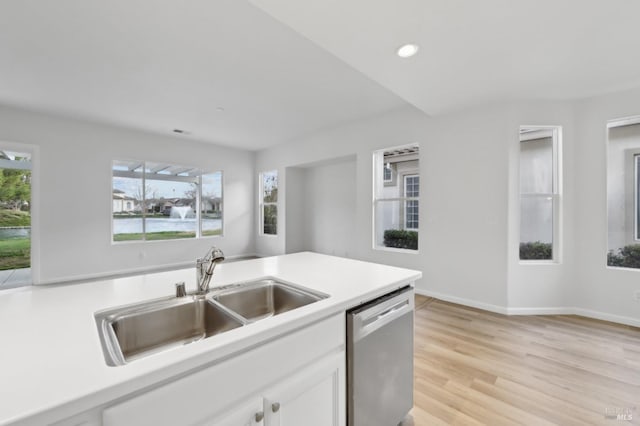 kitchen with white cabinets, light hardwood / wood-style floors, sink, and stainless steel dishwasher