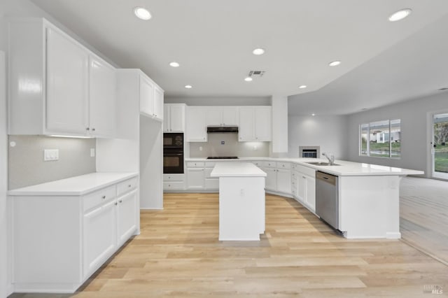 kitchen featuring sink, a center island, white cabinetry, black appliances, and kitchen peninsula