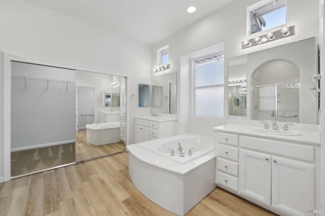 bathroom with vanity, independent shower and bath, and hardwood / wood-style floors