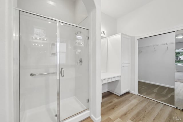 bathroom featuring hardwood / wood-style flooring and walk in shower