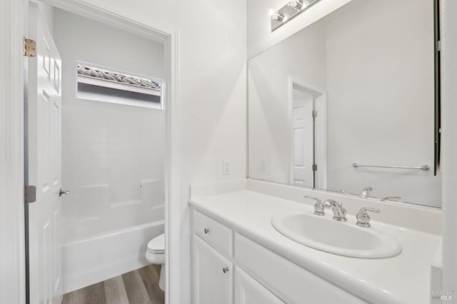 full bathroom with toilet, vanity, hardwood / wood-style floors, and tub / shower combination