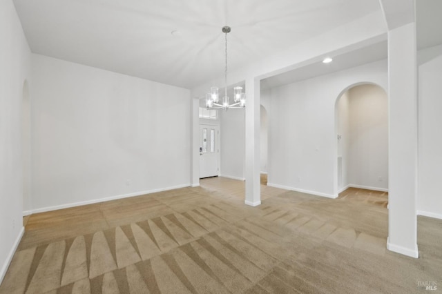 unfurnished dining area featuring light colored carpet and an inviting chandelier