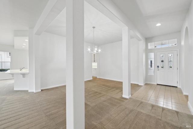 carpeted foyer featuring a notable chandelier