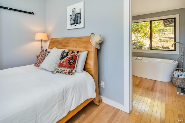 bedroom featuring baseboards and hardwood / wood-style flooring