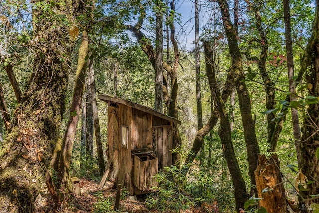 view of shed with a view of trees